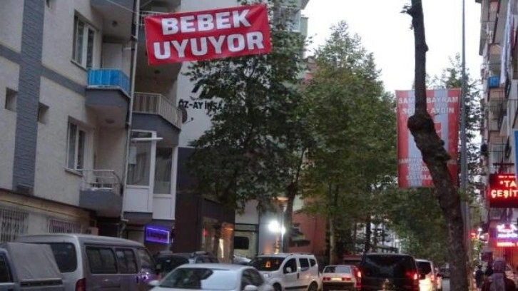 Araç gürültüsünden uyuyamayan bebeği için caddeye "Bebek uyuyor" afişi astı