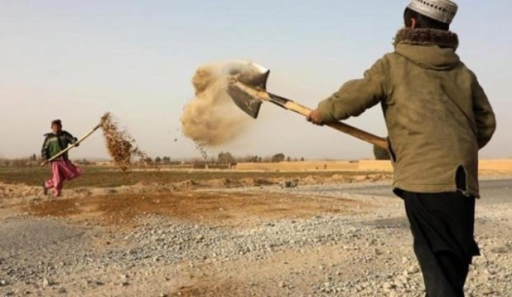 Bombaların tahrip ettiği yolları Afgan çocuklar onarıyor