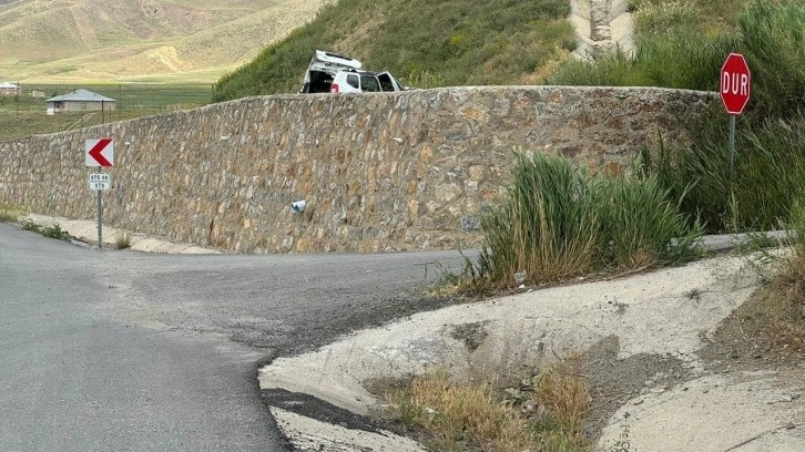 Kara yolundaki çukura giren otomobil istinat duvarını aştı