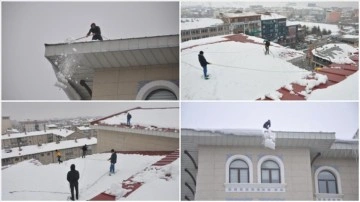 Muş'ta işçiler bellerine bağladıkları iplerle çatılarda kar temizliği yapıyor.